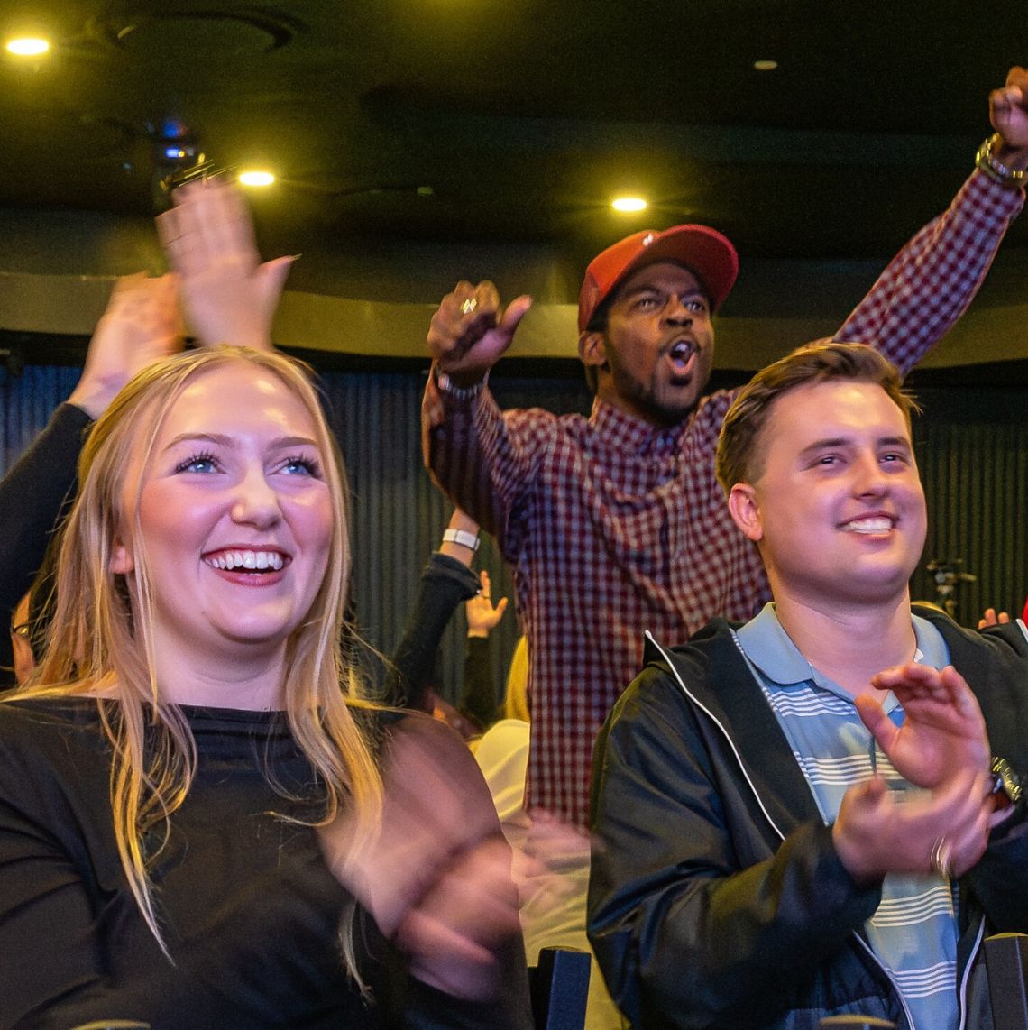 Group of coworkers at a theater venue cheering