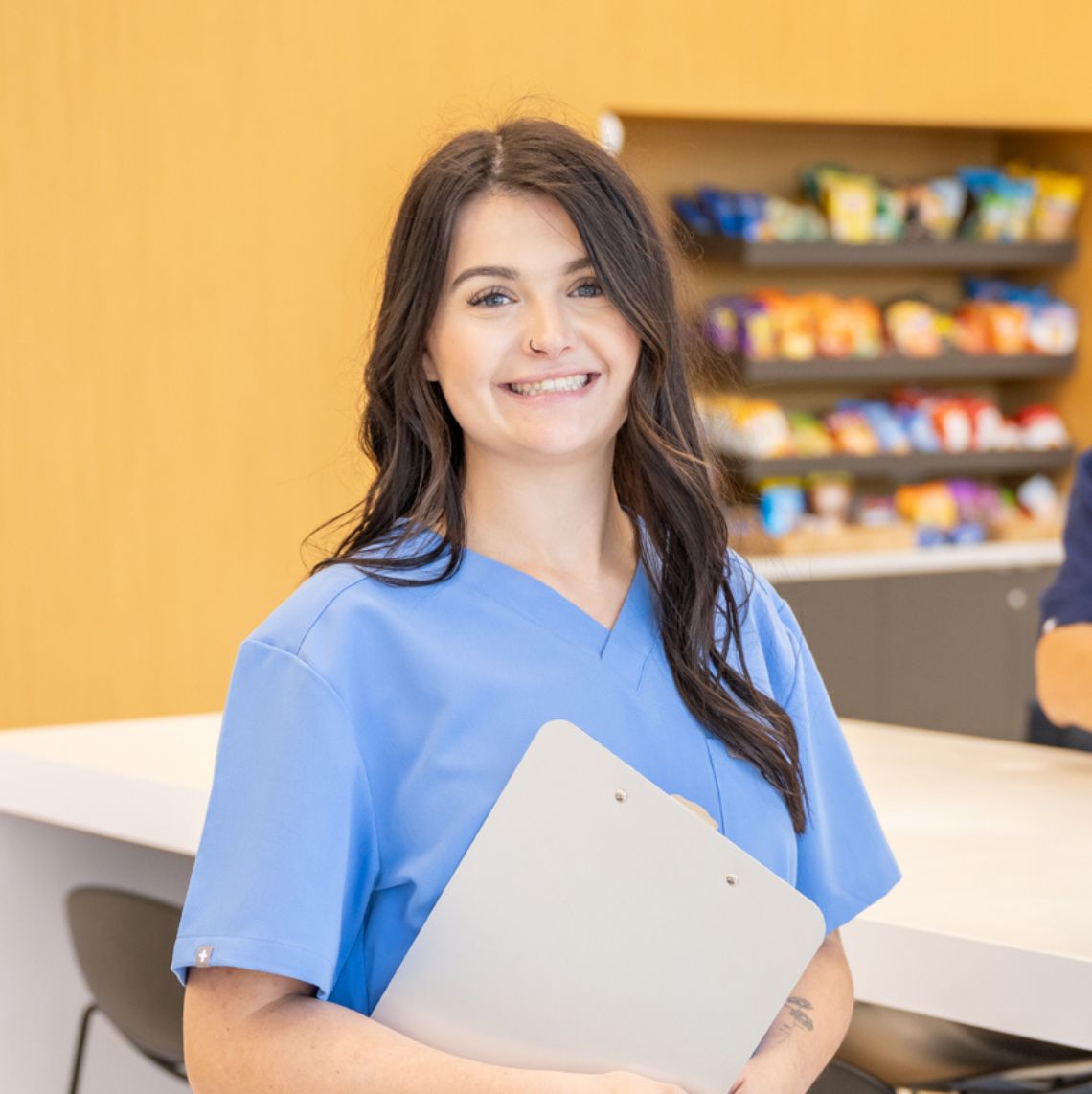 Young woman holding a clipboard and smiling at the camera